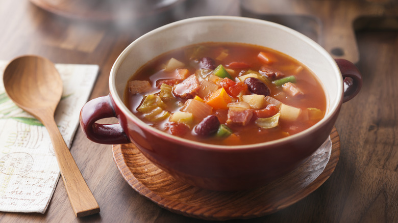 Bowl of vegetable soup with a spoon on the side