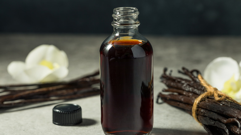 bottle of vanilla extract next to vanilla beans