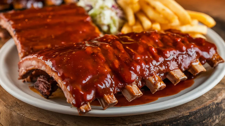 A plate of BBQ ribs with French fries and slaw.