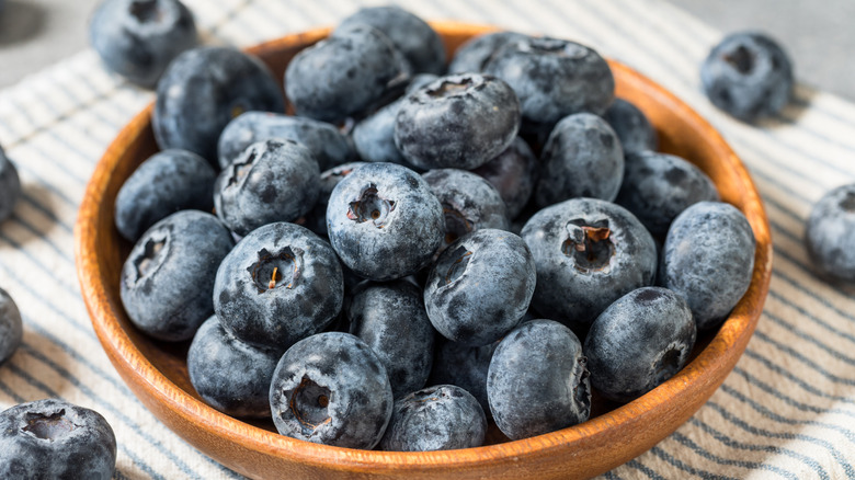 blueberries rest in a wooden bowl