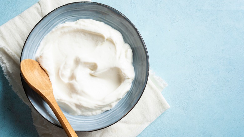 Homemade Greek yogurt in a blue bowl with a wooden spoon