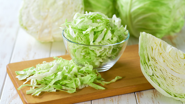 Whole, wedged, and shredded cabbage all in one frame.
