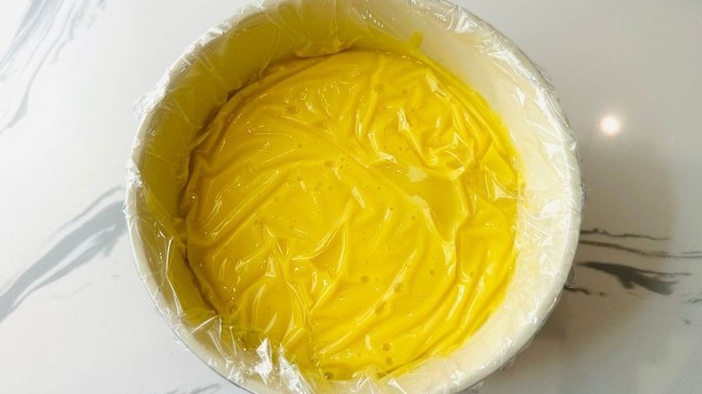 Custard in bowl covered with plastic wrap