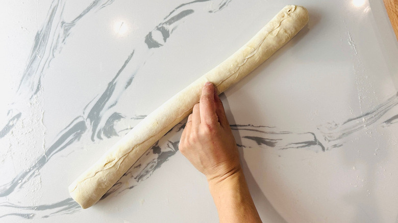 Finger pressing in the seam on dough log