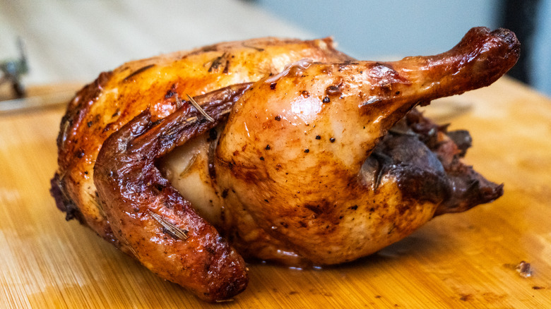 Roasted whole chicken on a wooden cutting board