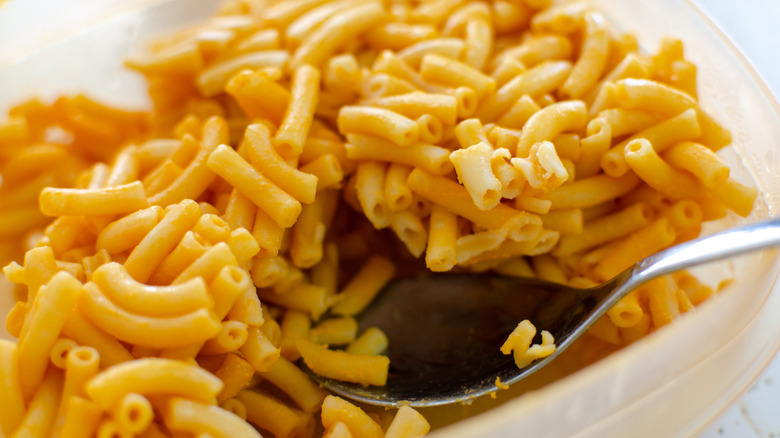 Spoon scooping Kraft macaroni and cheese from bowl