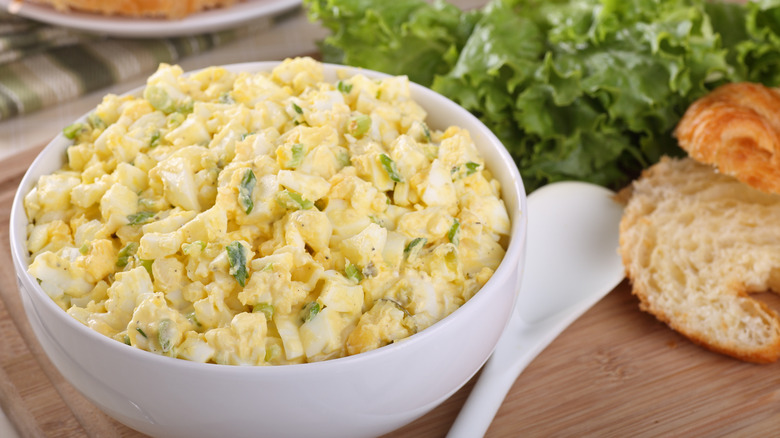 A white bowl full of egg salad.