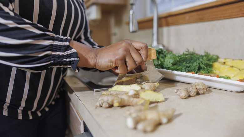 A woman cuts ginger