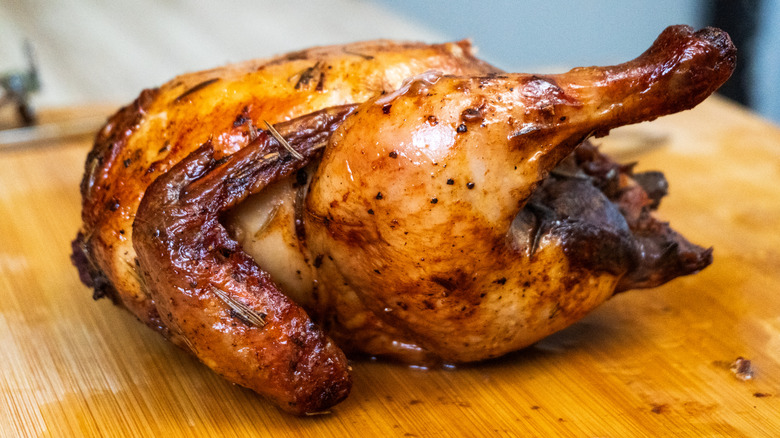 rotisserie chicken on a wooden cutting board