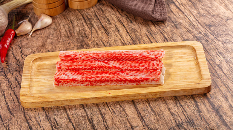 Imitation crab sticks on a wooden cutting board.