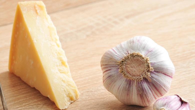 A wedge of parmesan and a globe of garlic.