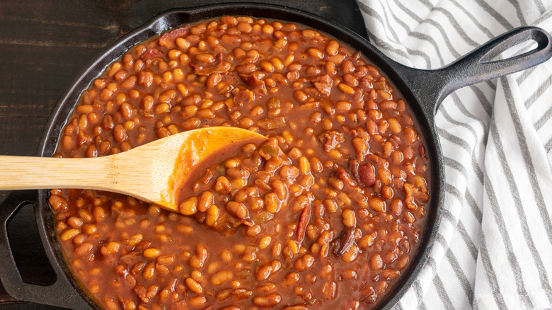 Baked beans simmer in a cast iron skillet