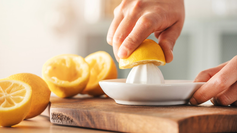 Hands juicing a lemon.