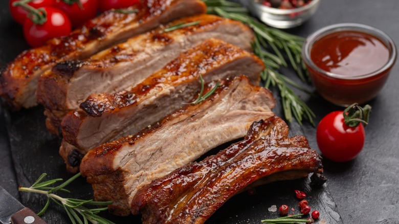 Delicious sticky grilled ribs on a gray surface.