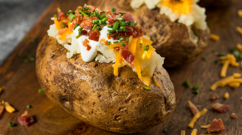 A baked potato with sour cream and bacon bits