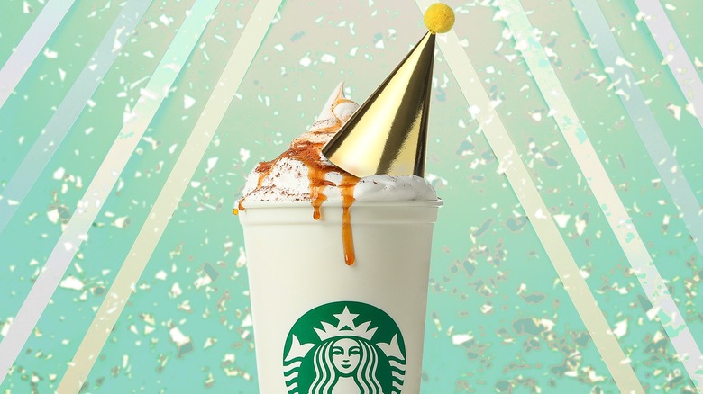 Starbucks drink with whipped cream and a birthday hat
