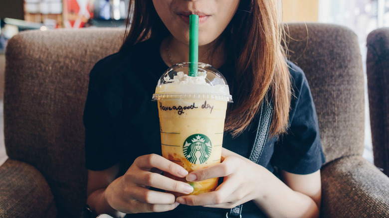 Person drinking a Starbucks drink with "Have a good day" written on it