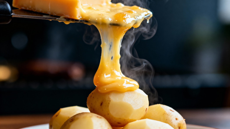 Melted raclette cheese on top of potatoes