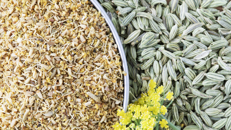 A bowl of fennel pollen beside fennel seeds and flower, photographed from above.