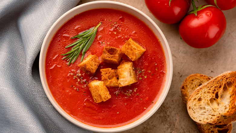 A bowl of warm tomato soup on a table.