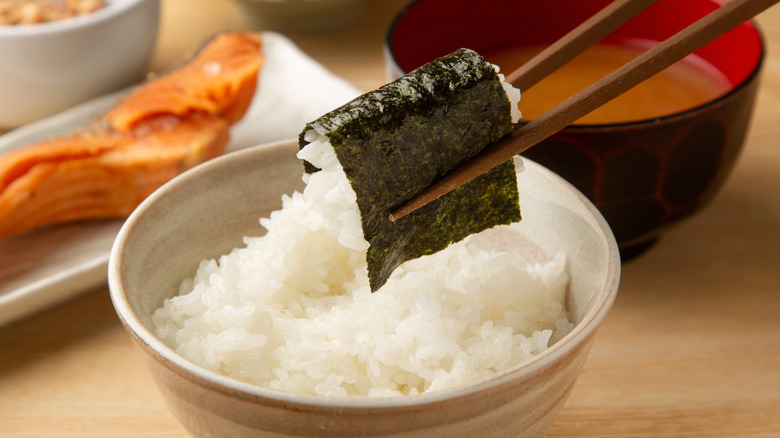 Image of a Japanese breakfast: Seasoned rice with nori seaweed picked up with chopsticks