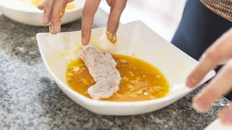 Flour-dredged chicken in egg wash