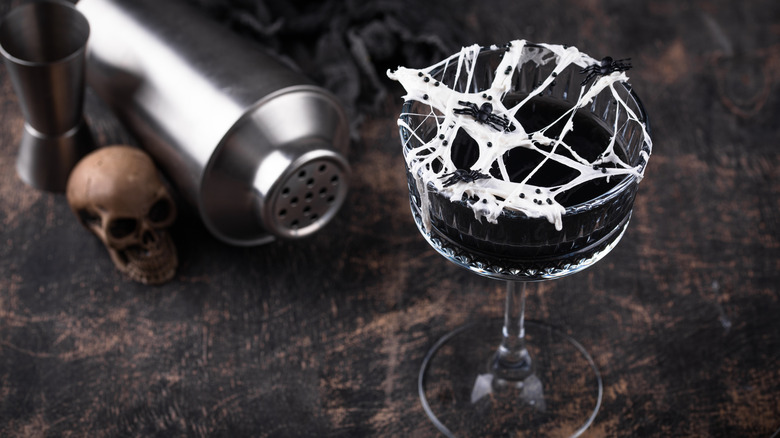 black cocktail with marshmallow spiderweb