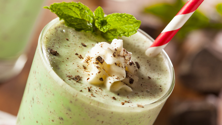 Close up of Shamrock shake with mint leaves and red and white straw