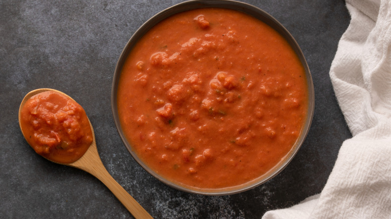 creamy tomato sauce in a bowl with a wooden spoon on the side