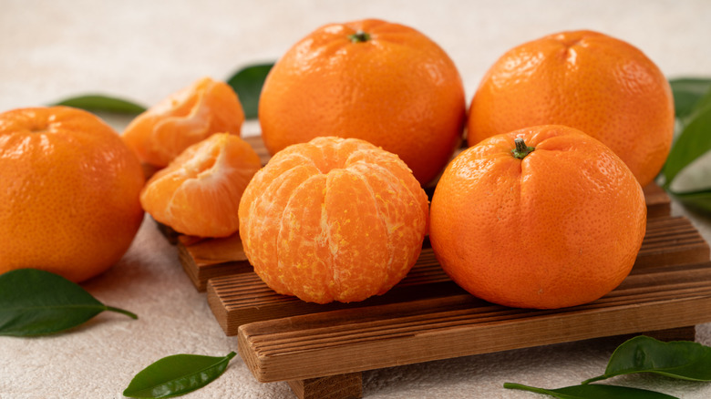 mandarin oranges on a wooden cutting board