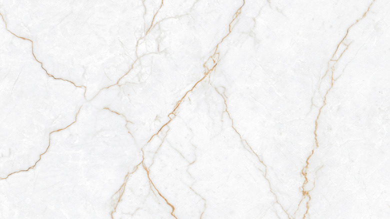 A white marble backsplash with gold seams