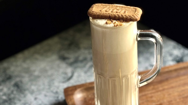 a vanilla cocktail milkshake in a tall glass topped with a biscuit