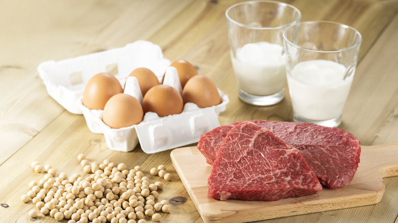 Eggs, milk, and steak displayed on a wooden countertop