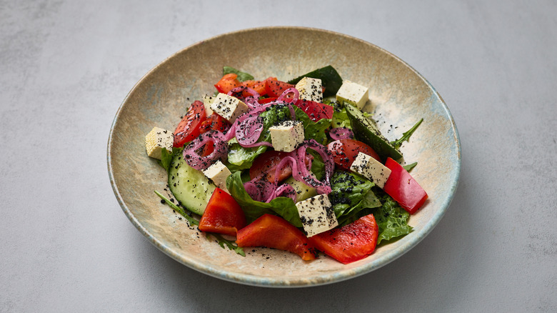 prepping marinated Greek salad
