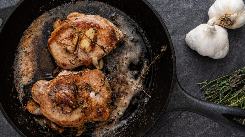 Pan-fried pork chops with thyme and garlic.
