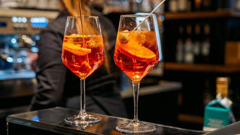 Two wine glasses with Aperol spritz on a bar