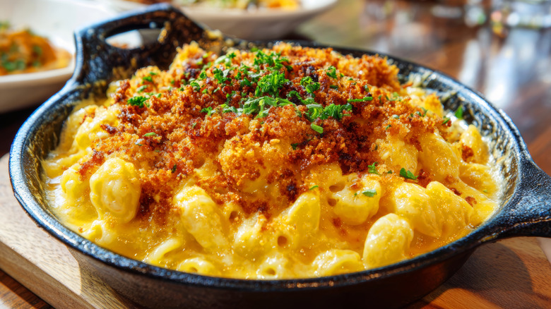 Mac and cheese garnished with breadcrumbs and herbs