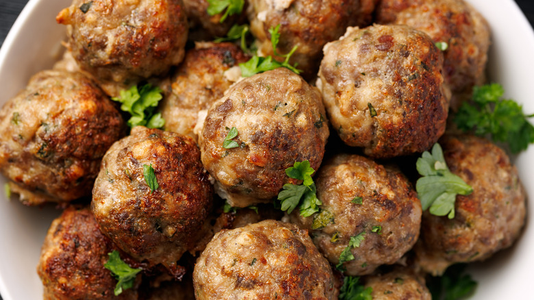 Meatballs on a plate covered with sprinkles of parsley