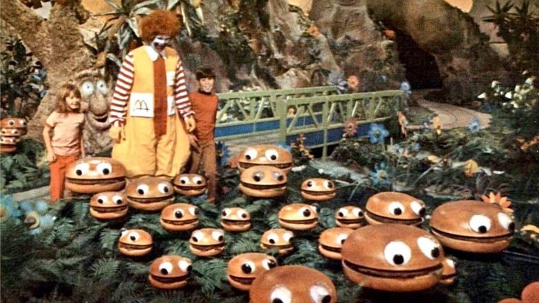 Romanld McDonald walking children through a hamburger patch in the first McDonaldland television ad