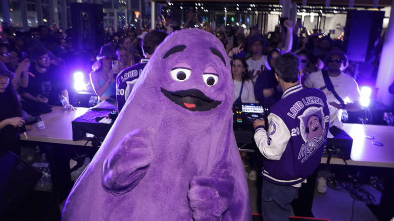 A person in a Grimace costume at a party