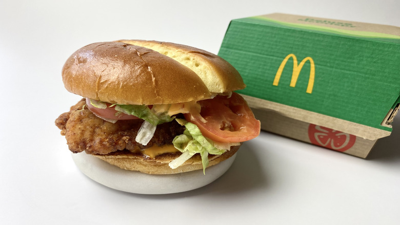 McDonald's Deluxe Spicy McCrispy sandwich with its box behind it