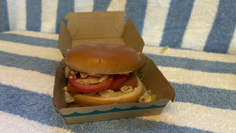 A Filet-O-Fish sandwich with tomato and lettuce, sitting in its box