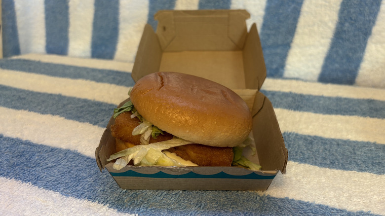 A Filet-O-Fish sandwich with lettuce and extra tartar sauce in its box