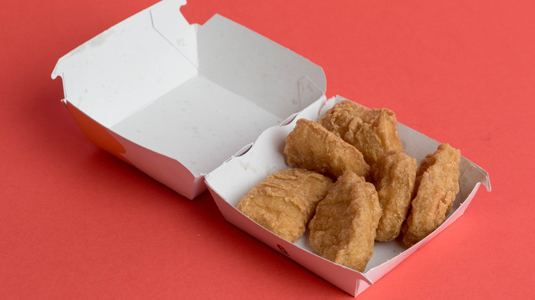 A carton of McDonald's McNuggets on a red background