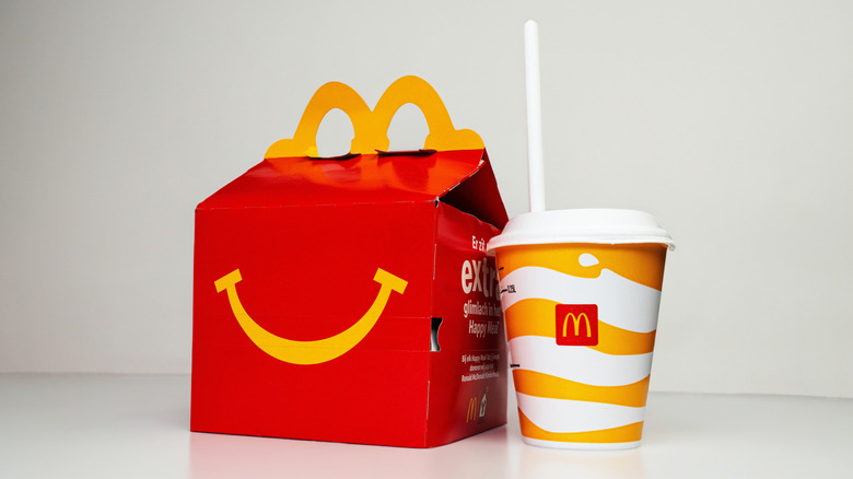 A red Happy Meal box and a child's drink on a white background