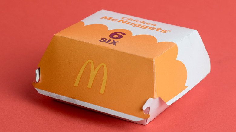 A box of six McDonald's McNuggets on a red background