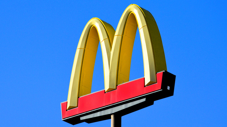 The golden arches on a McDonald's sign against a blue sky