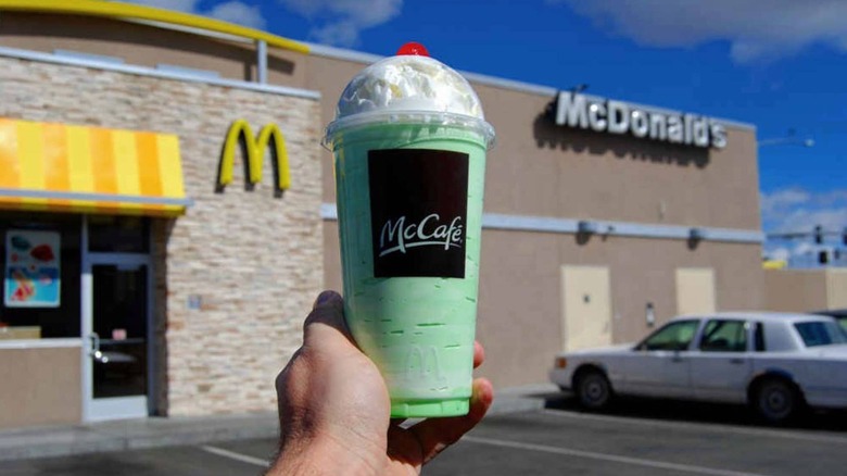 Person holds Shamrock Shake in front of McDonald's