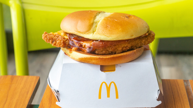 Two different sandwiches from McDonald's held on top of one another, one spicy and one regular.