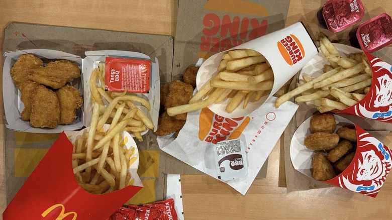 Nuggets and fries from McDonald's, Burger King, and Wendy's splayed out on a table